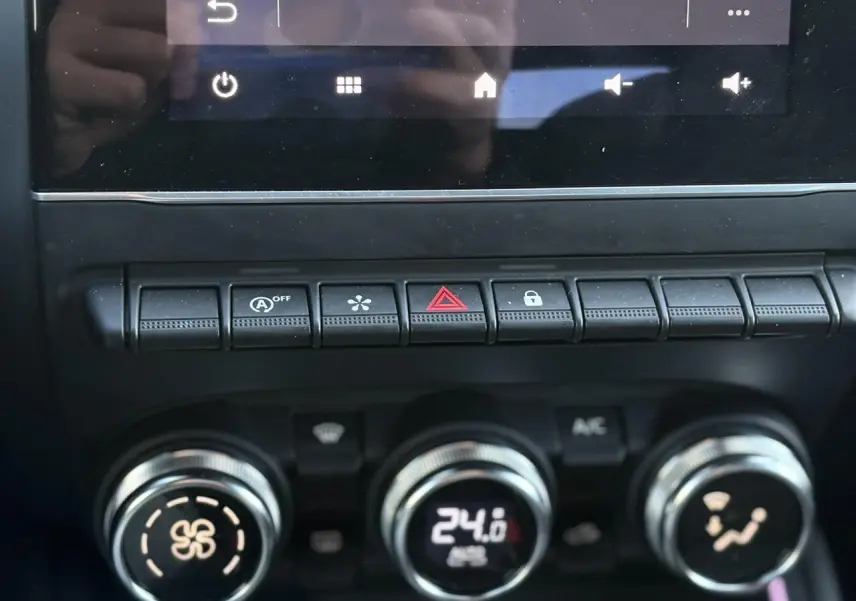 Gros plan sur la console centrale de la Renault Clio 2025 gris schiste, montrant les commandes de climatisation et les boutons de fonction.