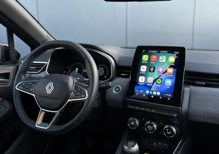 Vue intérieure centrée sur le volant multifonction et l’écran tactile 9,3 pouces de la Renault Clio gris schiste.