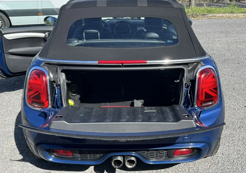 Vue arrière d'une MINI Cabriolet F57 Cooper S bleu avec coffre ouvert et feux arrière à motif Union Jack.