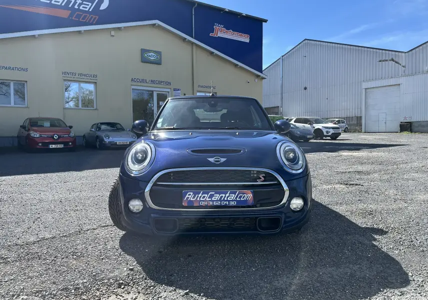 Vue frontale d'une MINI Cabriolet F57 Cooper S bleu avec calandre chromée et logo S visible, capote noire fermée.