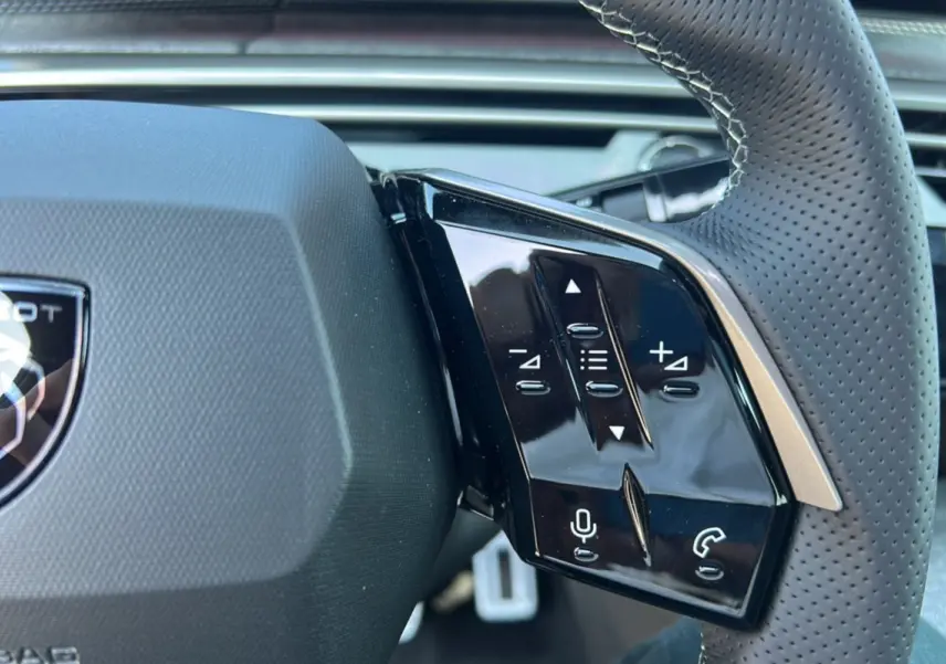 Gros plan sur la commande multifonctions droite du volant cuir perforé du Peugeot 3008 New Hybrid gris titane.