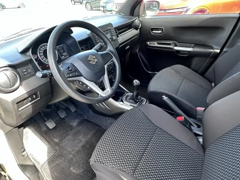 Intérieur de la Suzuki Ignis 2023 beige, vue côté conducteur montrant volant, tableau de bord et boîte manuelle.