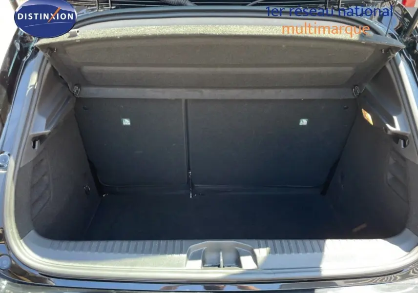 Coffre ouvert vu de l'arrière d'une Renault Clio noir étoile métal, montrant l'espace de rangement vide.