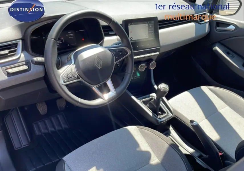 Vue intérieure avant de la Renault Clio V BluedCi 100ch Evolution 2025, volant cuir, tableau de bord moderne et sièges tissu gris.