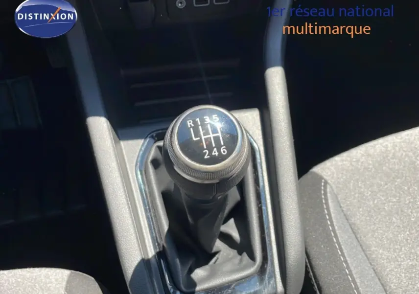 Gros plan sur le levier de vitesses manuel de la Renault Clio 2025, finition noire avec coutures blanches visibles sur le siège.
