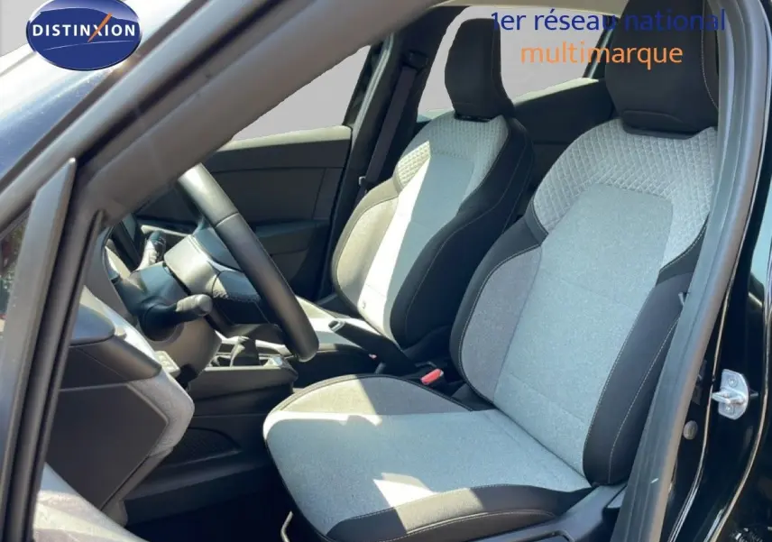 Vue intérieure côté conducteur de la Renault Clio noire étoile métal, mettant en valeur les sièges tissu gris et noir au design moderne.