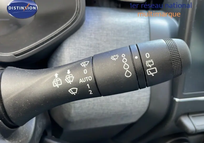 Gros plan sur la manette de commande des essuie-glaces dans l'habitacle d'une Renault Clio noire étoile métal.