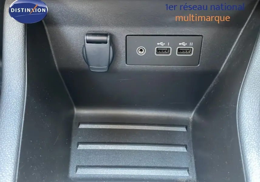 Gros plan sur la console centrale intérieure de la Renault Clio noire, montrant prises USB et prise jack.