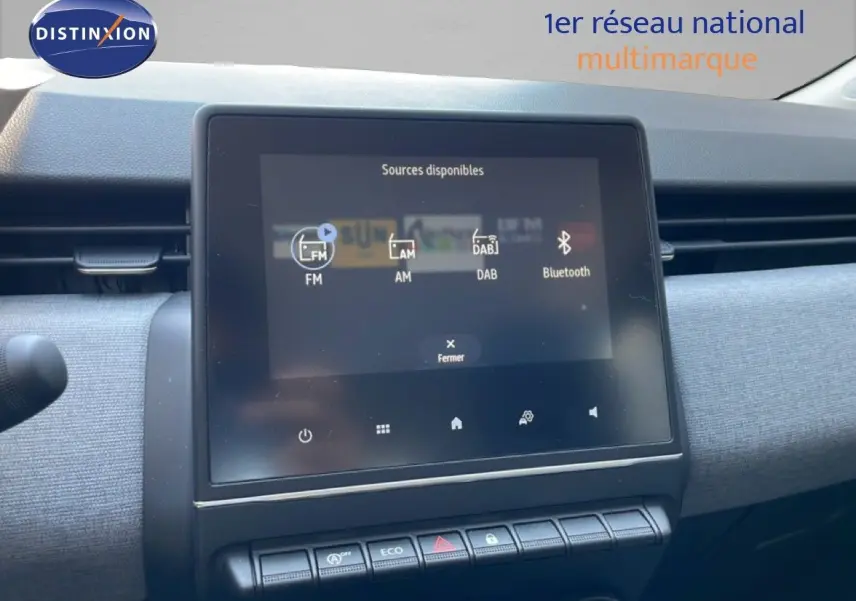 Vue intérieure centrée sur l’écran tactile multimédia et la planche de bord grise de la Renault Clio noire 2025.