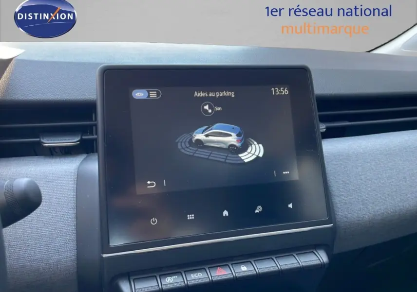 Vue rapprochée de l’écran tactile central affichant l’aide au parking dans l’habitacle gris clair d’une Renault Clio noire.