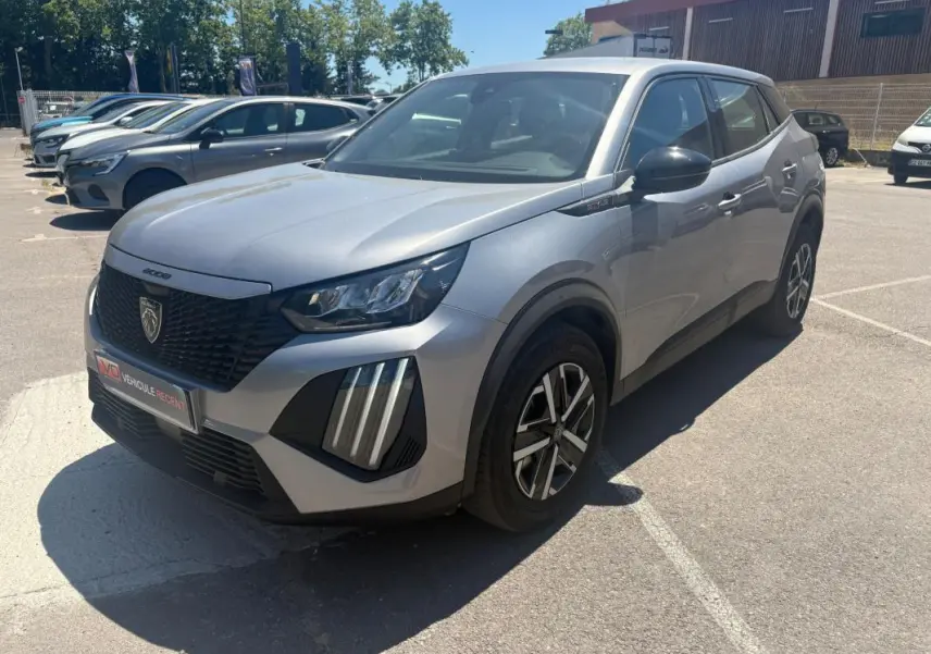 Peugeot 2008 Hybrid 145 gris vue 3/4 avant droit, avec calandre noire et feux LED verticaux distinctifs.