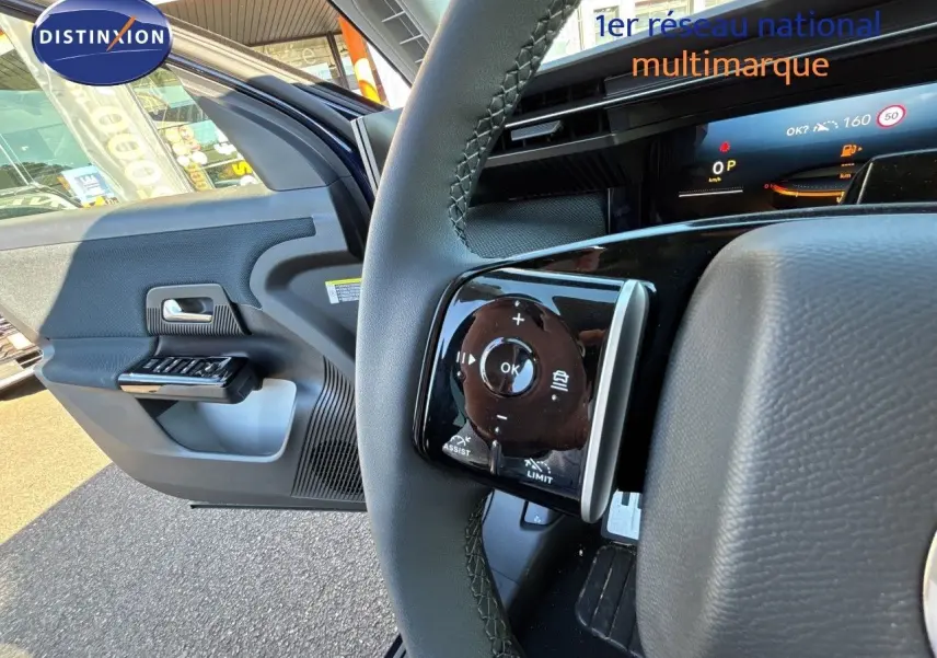 Gros plan sur le volant et la portière ouverte côté gauche d’un Citroën C5 Aircross Hybrid bleu Eclipse métal avec toit noir.