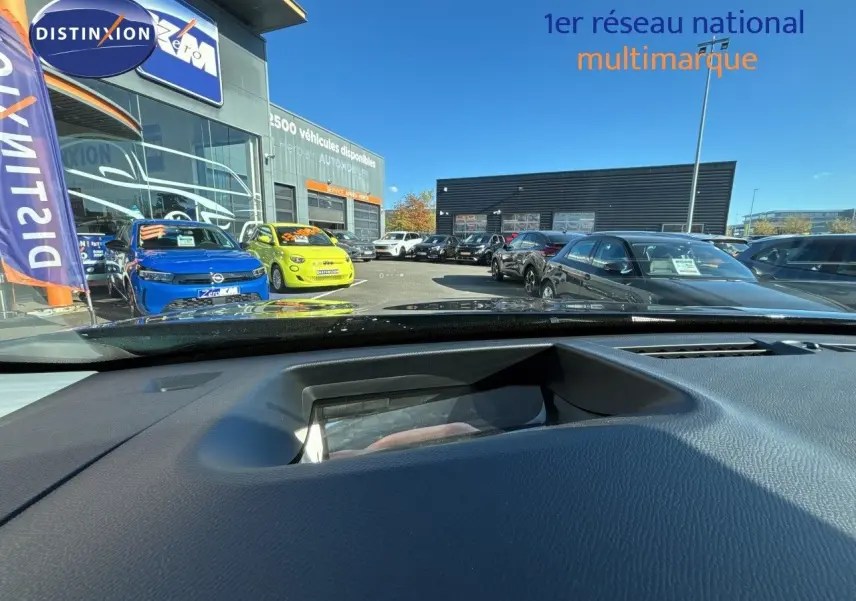 Vue depuis l'intérieur vers l'extérieur, montrant un Citroën C5 Aircross bleu Eclipse métal avec toit noir en 3/4 avant gauche.