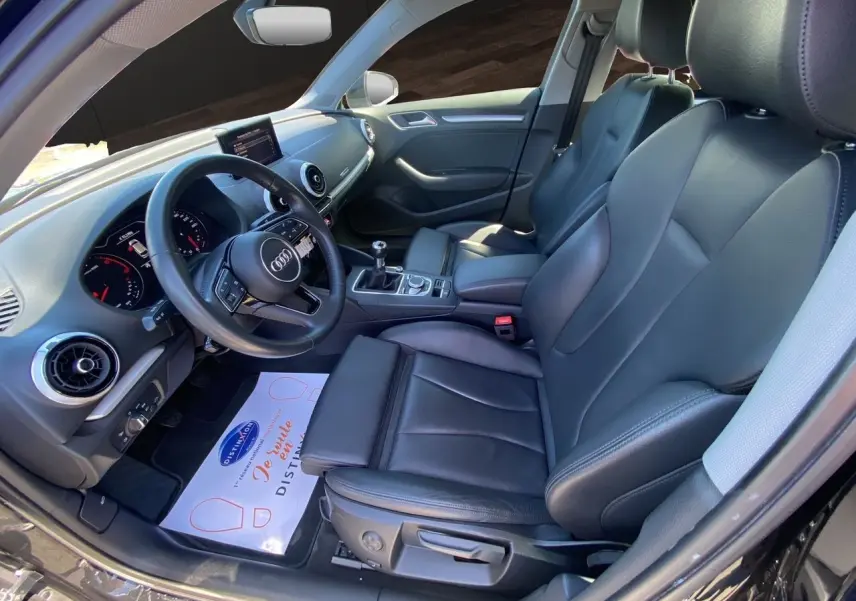 Vue intérieure côté conducteur de l'Audi A3 Sportback 2020 avec sellerie cuir noir et volant multifonction.