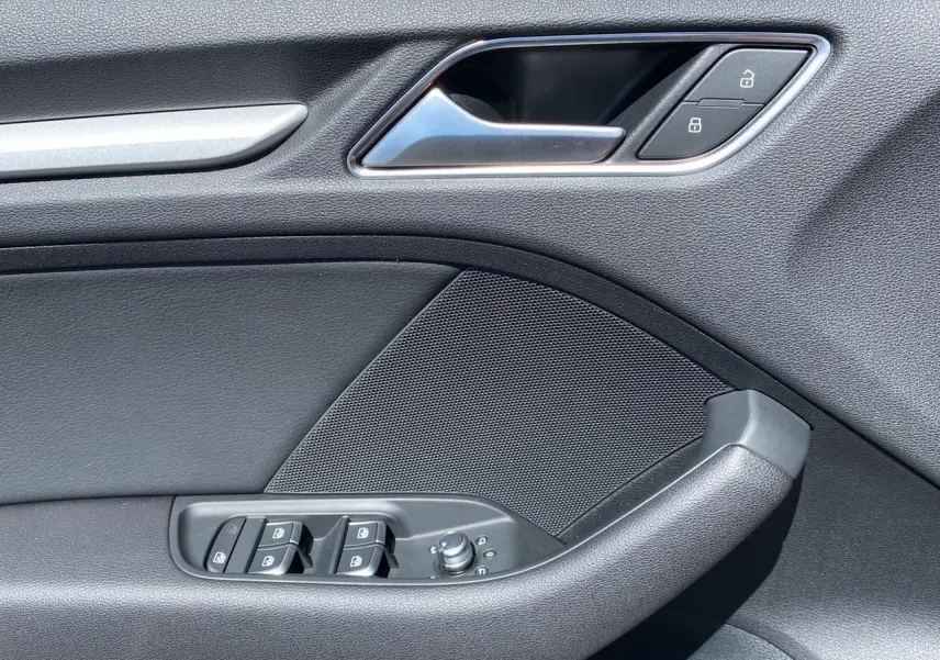 Détail de la porte côté gauche de l'Audi A3 Sportback 2020 noire, avec commandes de vitres et verrouillage.