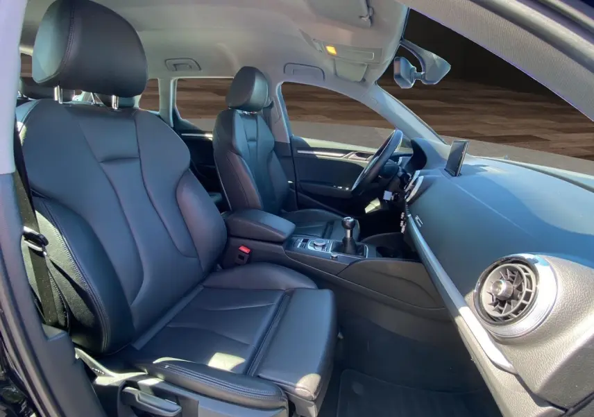 Intérieur avant d'une Audi A3 Sportback 2020 avec sellerie cuir noir chauffant et console centrale manuelle visible.