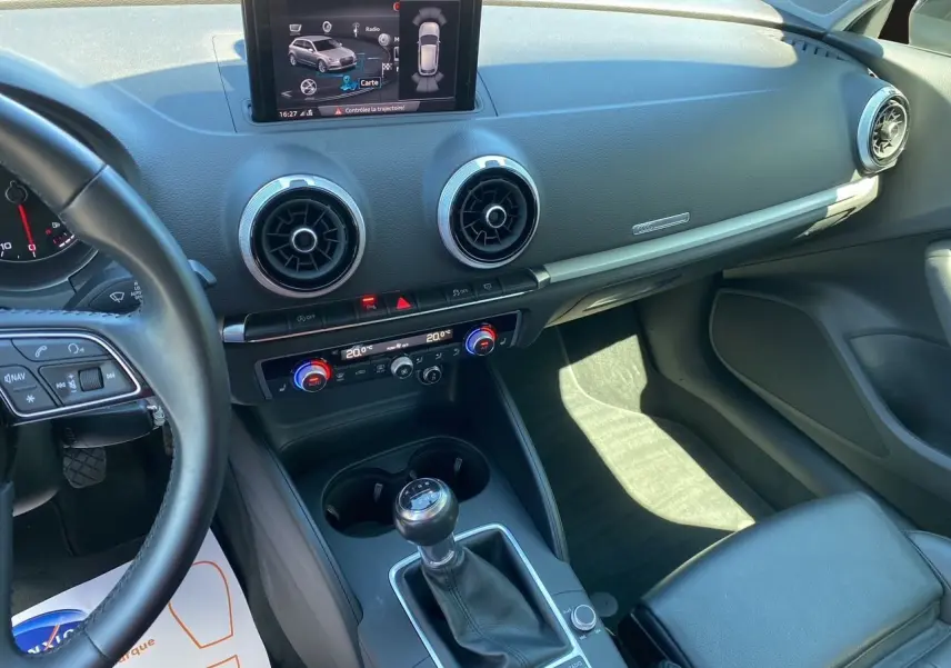 Intérieur Audi A3 Sportback 2020 noir, vue du poste de conduite avec écran multimédia et levier de vitesse manuel.