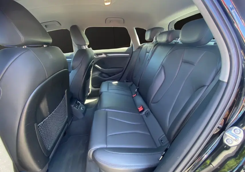 Vue intérieure côté droit montrant la banquette arrière en cuir noir de l'Audi A3 Sportback 2020.