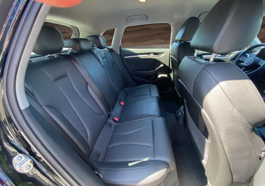 Vue intérieure côté gauche montrant la banquette arrière en cuir noir chauffant de l'Audi A3 Sportback 2020.