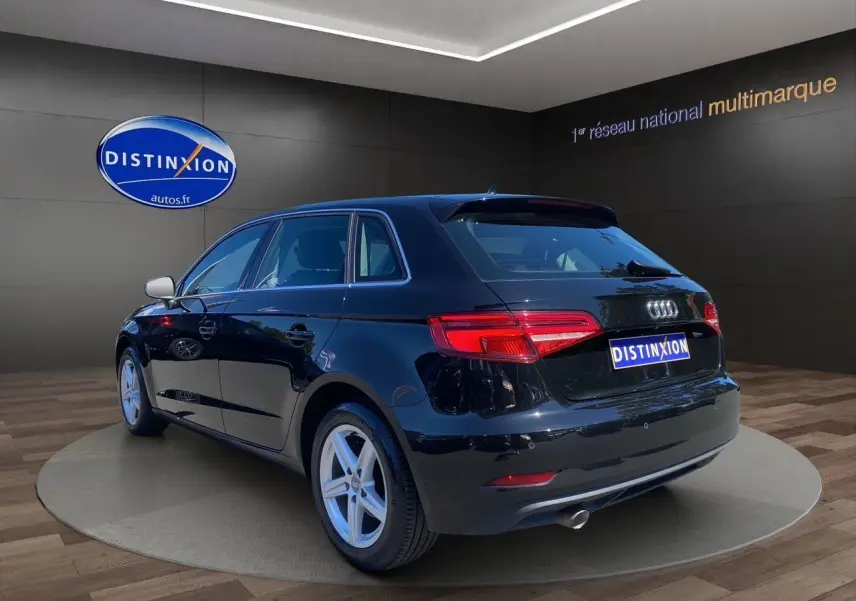 Audi A3 Sportback noire vue 3/4 arrière droit, avec feux arrière LED et jantes alliage 5 branches.