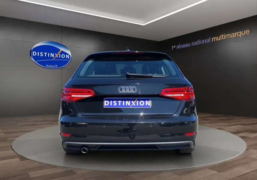 Vue arrière d'une Audi A3 Sportback noire 2020 avec feux arrière LED et sortie d'échappement unique visible.