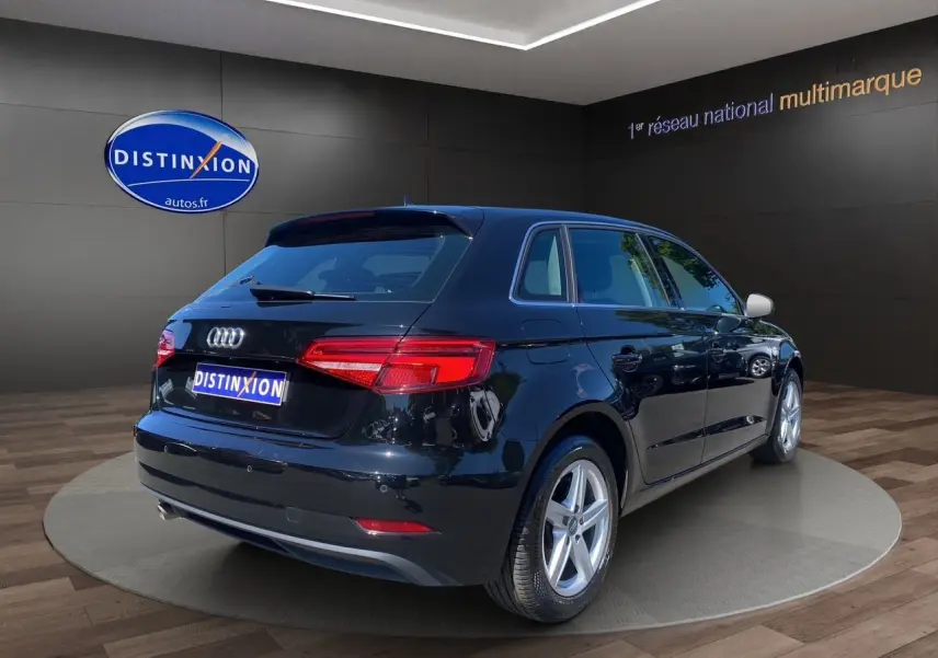 Audi A3 Sportback noir vue 3/4 arrière droit, feux arrière LED et jantes alliage 5 branches visibles.