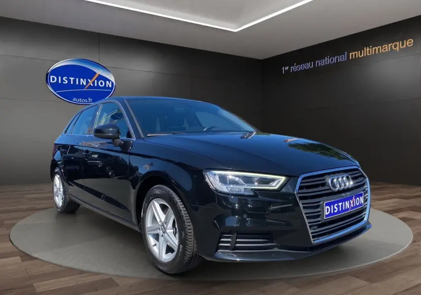 Audi A3 Sportback noire vue en 3/4 avant droit, avec projecteurs LED et jantes alliage 5 branches.