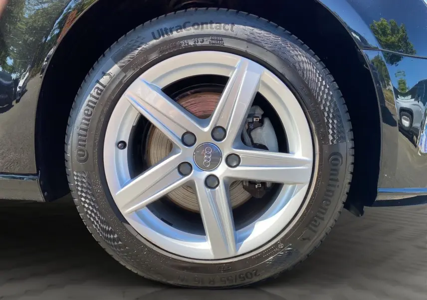 Gros plan sur la jante alliage 16 pouces 5 branches étoile de l'Audi A3 Sportback noire, avec pneu Continental visible.