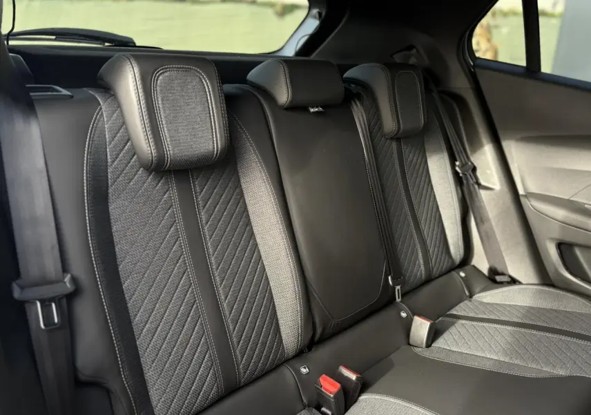 Vue rapprochée de la banquette arrière noire et grise du Peugeot 2008 Hybrid 145 e-DSC6 Allure avec appuie-têtes intégrés.