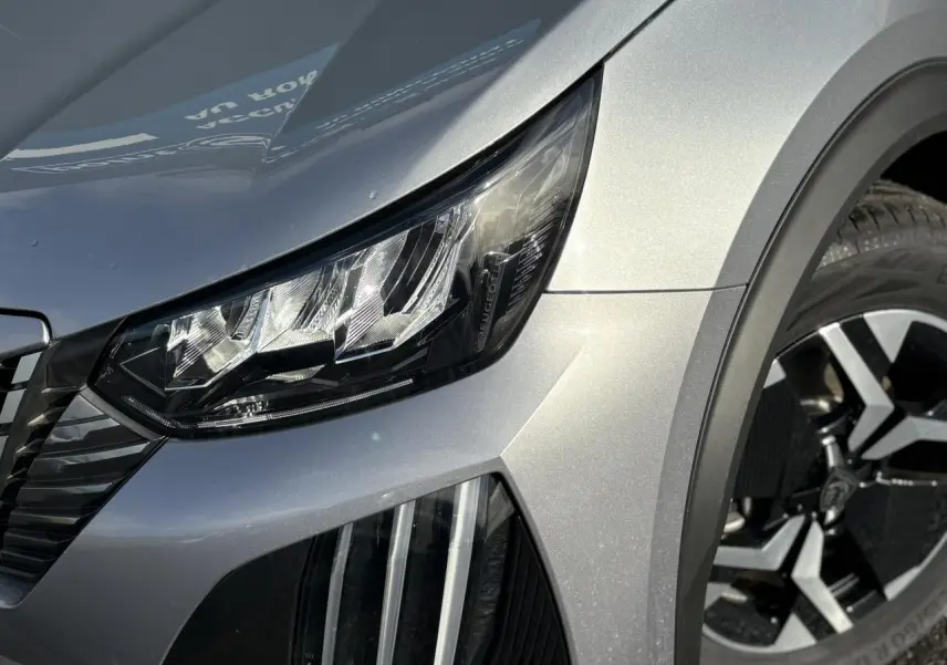 Gros plan sur l'avant droit gris Artense du Peugeot 2008 Hybrid 145 avec phare LED et jante alliage 17'' bi-ton.