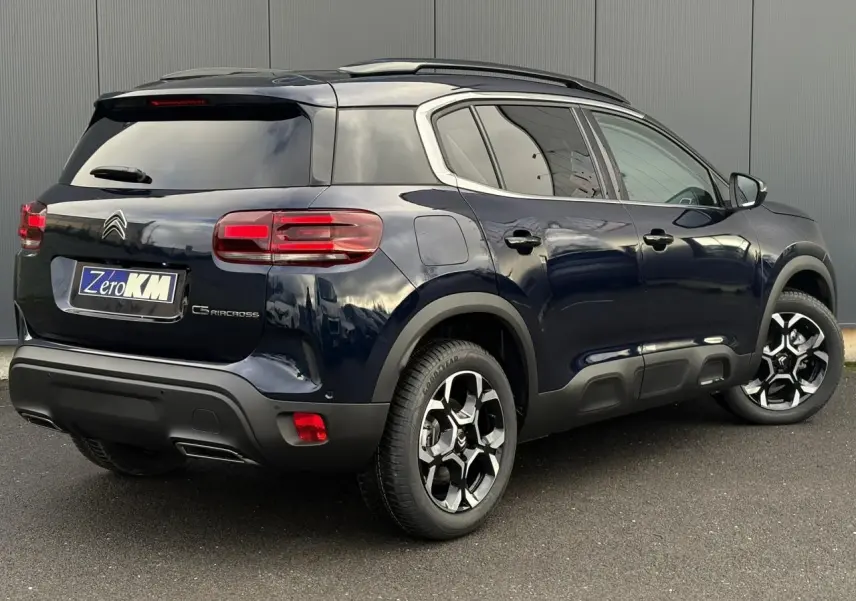 Vue 3/4 arrière droit d'un Citroën C5 Aircross Bleu Eclipse avec toit noir et jantes alliage bi-ton.