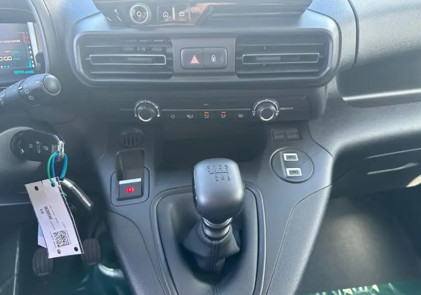 Vue intérieure centrée sur la console centrale et levier de vitesse manuel du Citroën Berlingo III blanc.