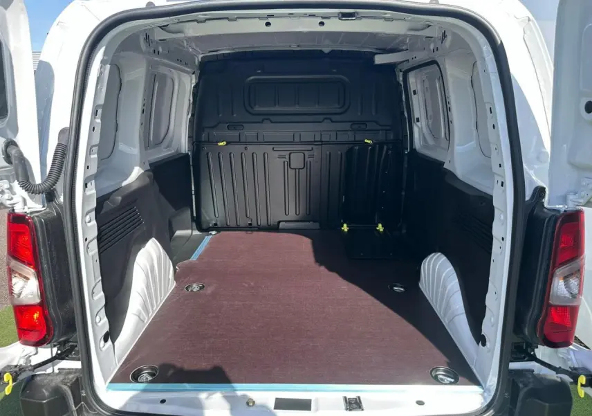 Vue arrière du Citroën Berlingo blanc Icy avec porte ouverte montrant la zone de chargement avec plancher bois antidérapant.