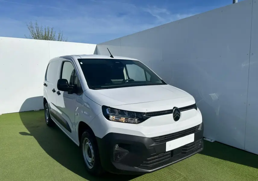 Vue 3/4 avant droite d’un Citroën Berlingo blanc Icy avec pare-chocs noir mat et jantes tôles grises.
