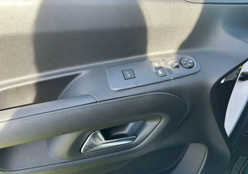 Gros plan sur la porte côté conducteur du Citroën Berlingo blanc Icy, avec commandes électriques des vitres et rétroviseurs.