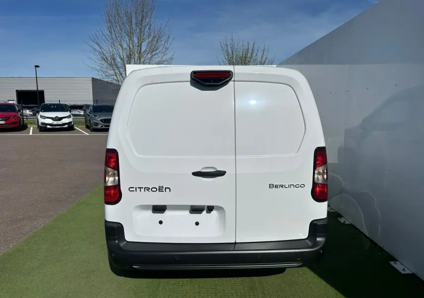 Vue arrière d'un Citroën Berlingo blanc Icy avec portes battantes et pare-chocs noir mat sur sol vert.