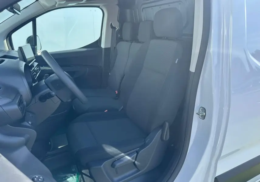 Vue intérieure côté conducteur du Citroën Berlingo blanc Icy, montrant les sièges tissu et le tableau de bord avec écran tactile.