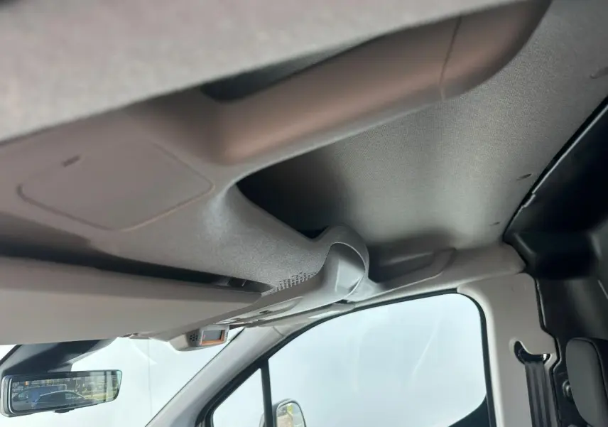 Vue intérieure côté passager du plafond et pare-soleil du Citroën Berlingo blanc Icy, avec rétroviseur central visible.