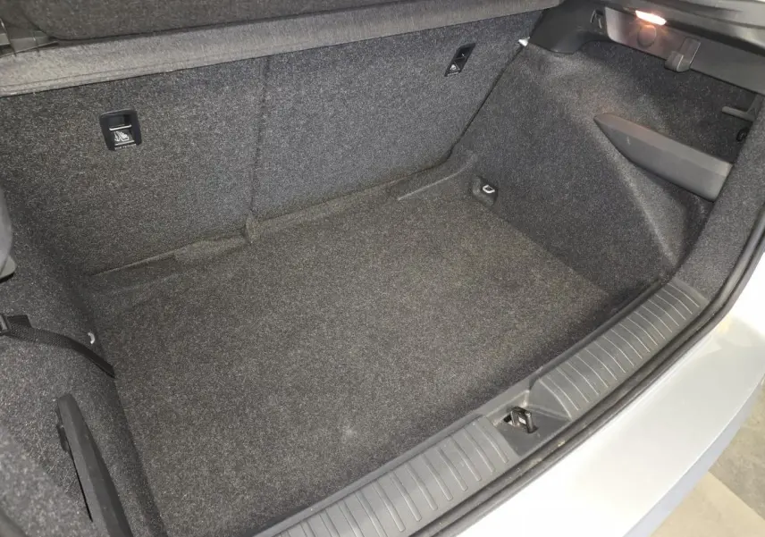 Vue rapprochée de l'intérieur du coffre gris clair du Skoda Kamiq 2023, montrant le revêtement et les fixations ISOFIX.