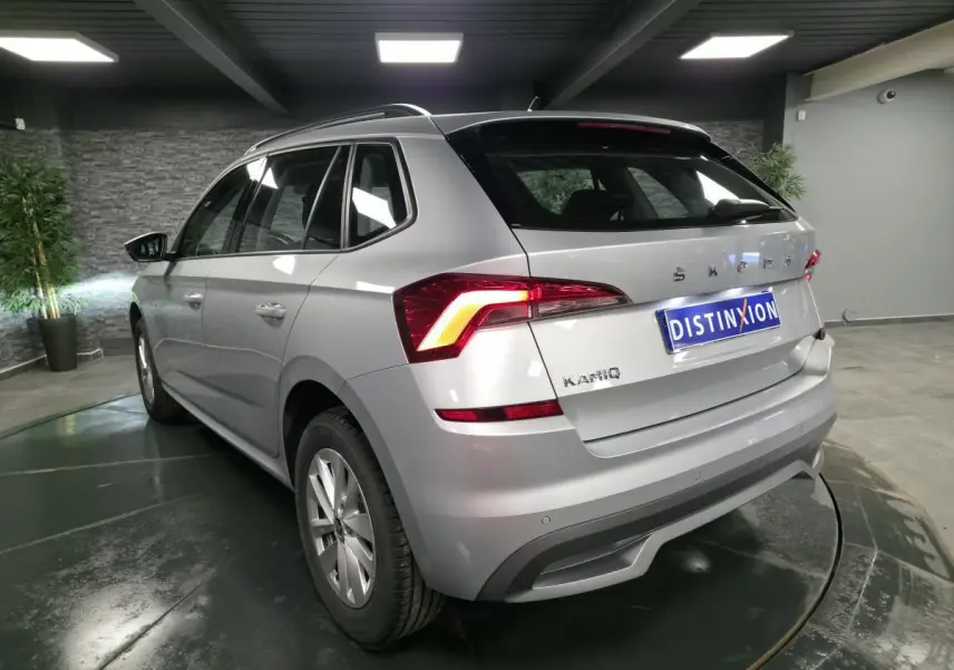 Vue 3/4 arrière droite d'un Skoda Kamiq gris métallisé avec feux arrière LED et jantes alliage 16 pouces.