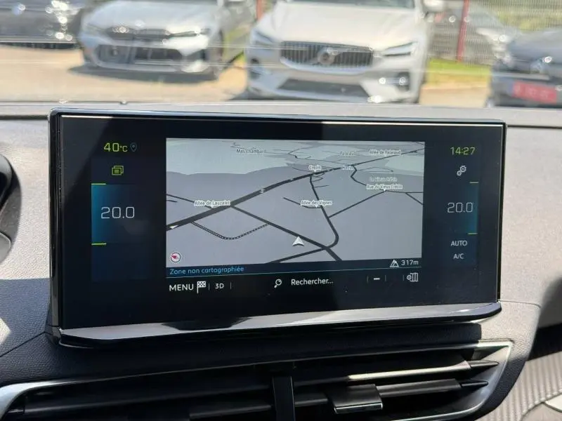Écran tactile central du Peugeot 3008 Hybride 2024 affichant la navigation, vu de face à l'intérieur du véhicule.