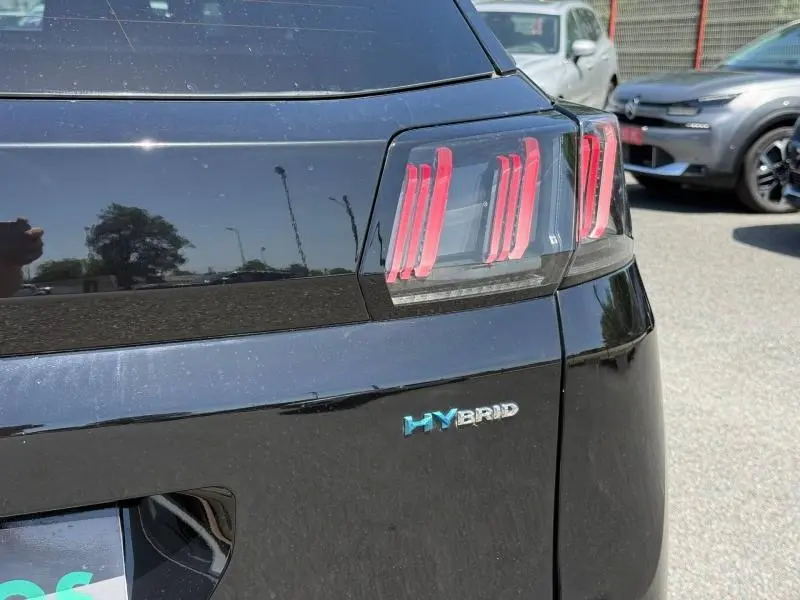 Gros plan sur l'arrière droit noir Perla Nera d'un Peugeot 3008 hybride avec feux arrière LED et badge HYBRID.