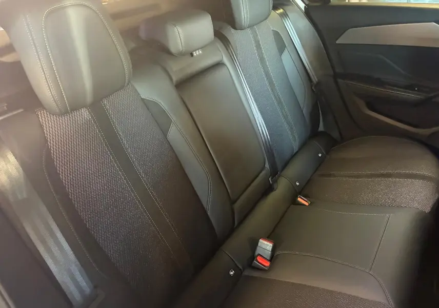 Vue intérieure montrant la banquette arrière noire de la Peugeot 308 1.2 Hybrid 136 E-DCS6 GT de 2025.