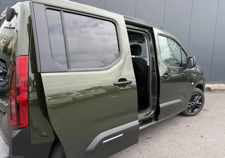 Vue 3/4 arrière droite du Citroën Berlingo Multispace vert Sirkka avec porte coulissante ouverte et vitres surteintées.