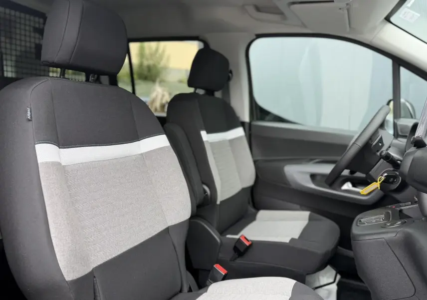 Vue intérieure côté gauche du Citroën Berlingo Multispace 2026, sièges tissu gris et noir avec détails clairs.