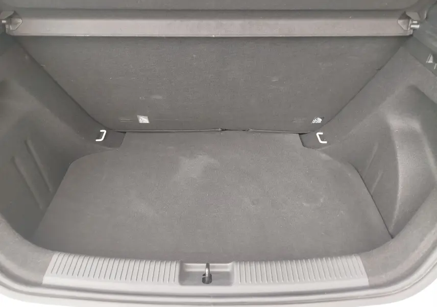 Coffre ouvert vu de face d’un MG3 1.5L HYBRID+ 195CH COMFORT en blanc Dover, intérieur noir et tapis de sol.