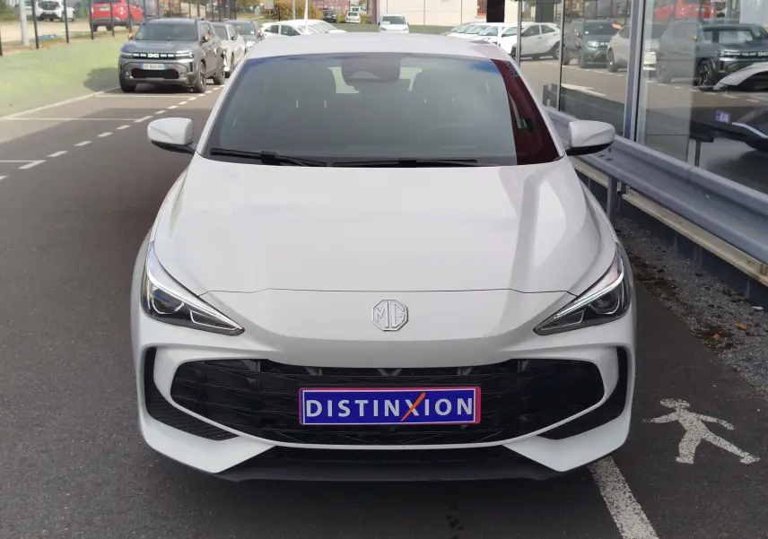 Vue avant d'une MG3 Dover White 2025 avec calandre noire et phares LED effilés, stationnée devant un showroom.