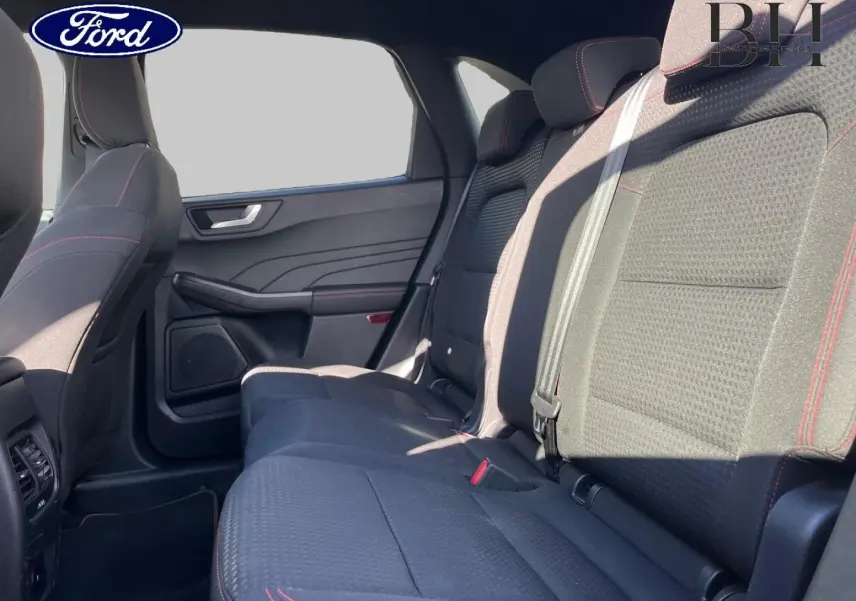 Vue intérieure côté droit sur la banquette arrière noire avec surpiqûres rouges du Ford Kuga 2023 finition ST-Line Business.
