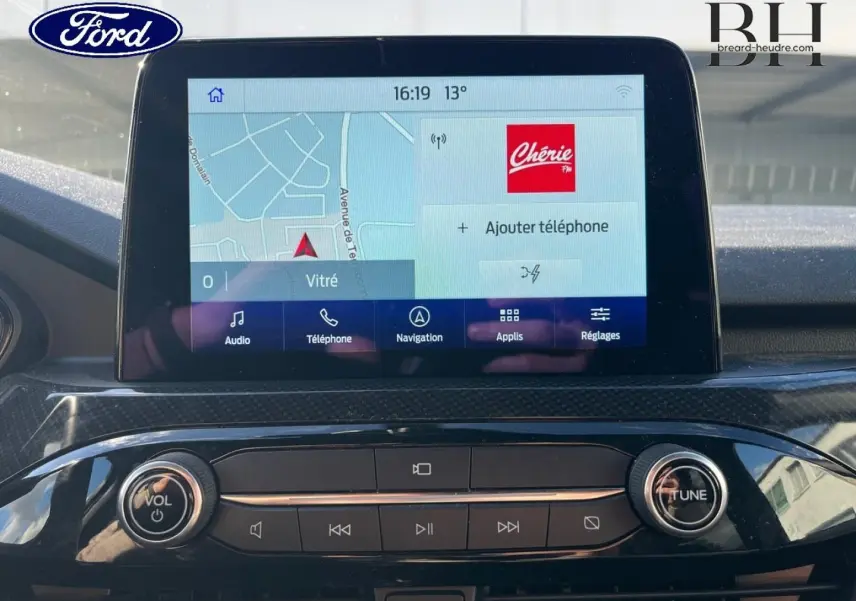 Écran tactile central du Ford Kuga 2023 avec interface navigation et commandes audio, vue intérieure frontale.