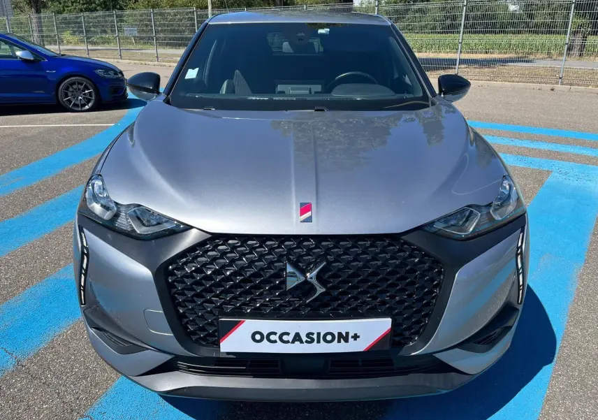 Vue avant d'un DS3 Crossback Performance Line gris métallisé avec calandre noire et badge DS distinctif.